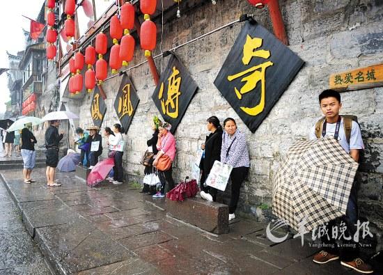 凤凰当地居民以为游客拍照谋生，一场降雨让他们的生意更加清淡 新华社发