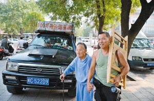 陈录雪拉着母亲的手，站在自己的“房车”旁。