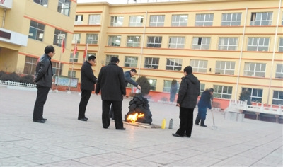 　1月3日下午5时许，五台县实验小学校园内，一名教职工将桶装机油淋在用木炭垒起的“旺火”堆上，为其助燃。