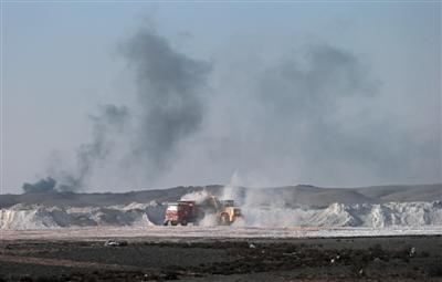 新疆宜化化工厂北侧一片开阔的荒漠上，从厂区进出的车辆满载工业废料及生活垃圾，直接倾倒在荒漠上。