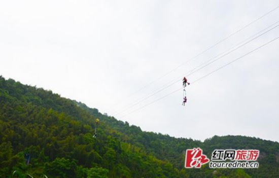 宁乡龙泉大峡谷的高空自行车项目，操作方式为一人在上制动自行车，带动另一搭乘在座椅上的人前进。杨烊图